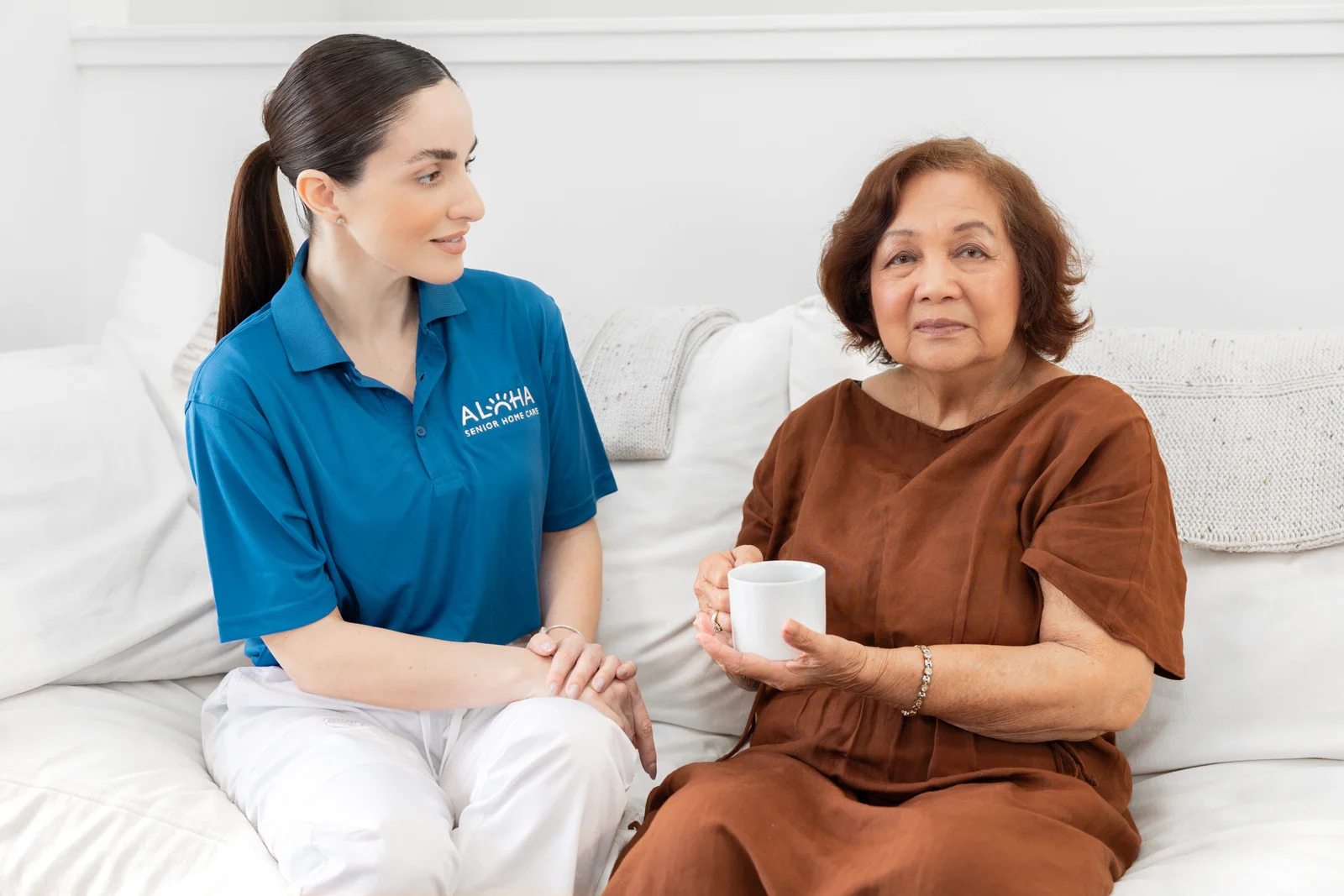 An Aloha caregiver sharing a warm moment with a senior woman at home